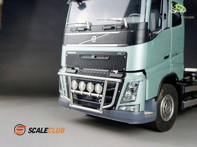 Vrachtwagen-model op schaal, turquoise cabine, met logo 'Scale Club'. Op een zwarte achtergrond. Focus op vooraanzicht en details.