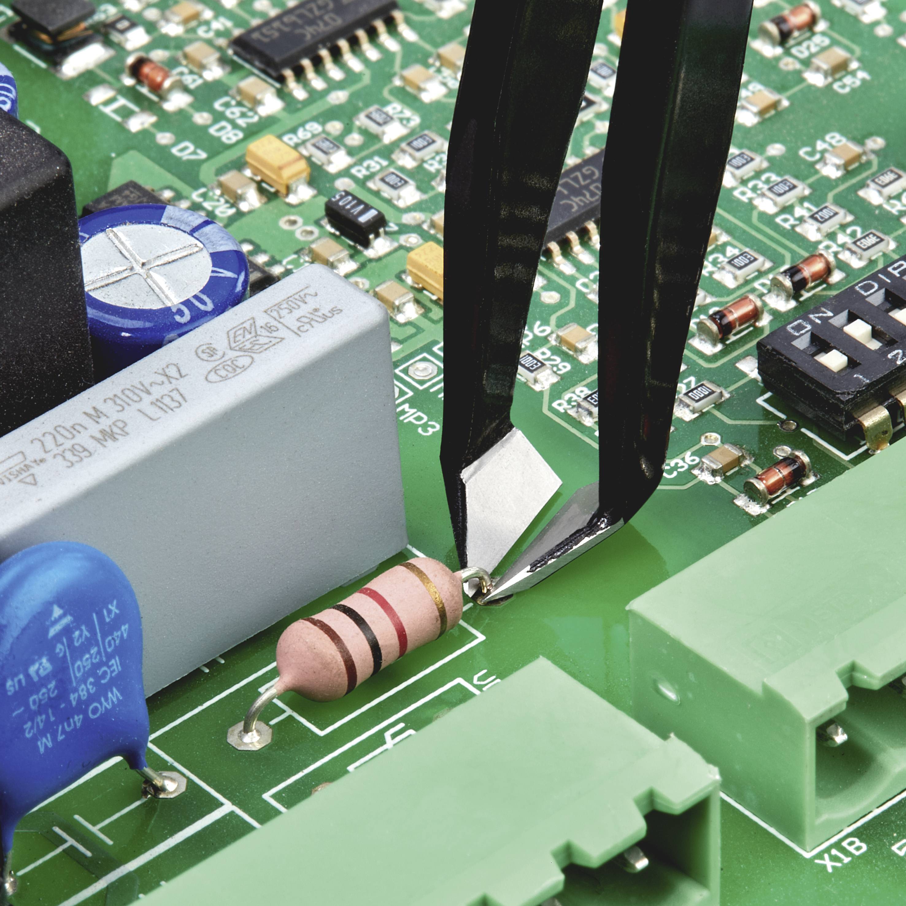 Close-up van een printplaat met elektronische componenten: weerstand, condensatoren en een pincet dat een component plaatst.