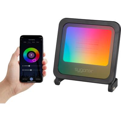 Een hand houdt een smartphone vast met een app om de kleurveranderende LED-lamp naast zich te bedienen. De lamp schijnt in regenboogkleuren.