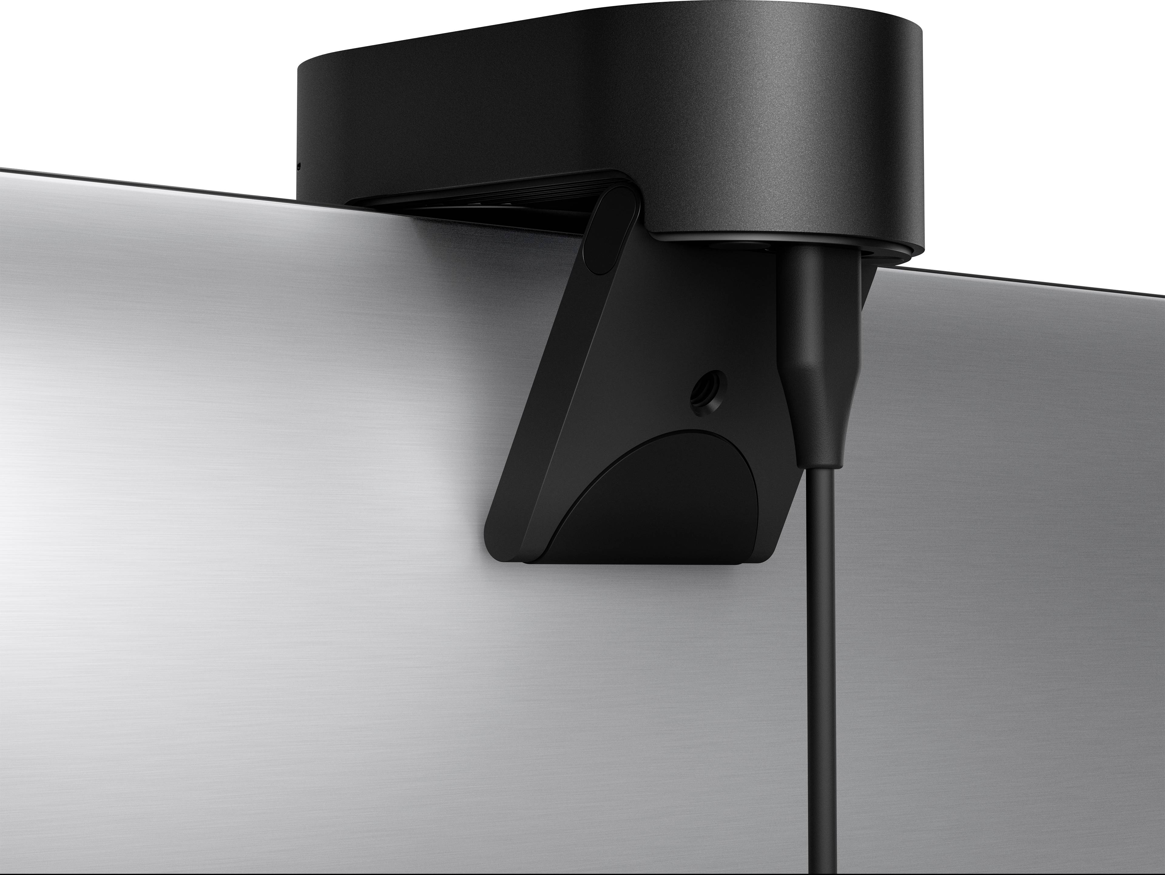 Een zwarte camera is bovenaan een scherm bevestigd, met een kabel die naar beneden hangt aan de rechterkant van de camera.