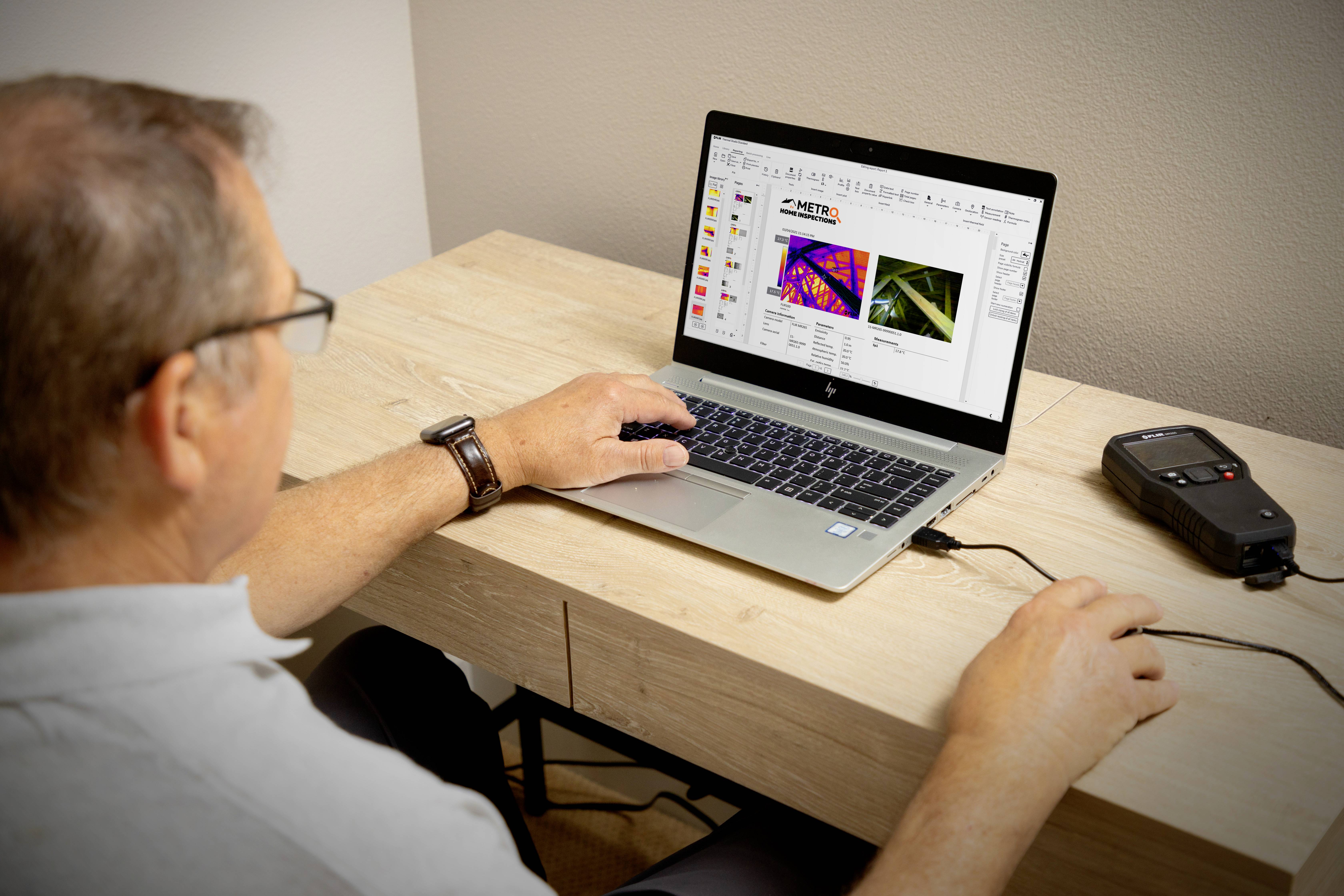 Een man werkt op een laptop waarop een diagram of analyse wordt weergegeven. Naast hem ligt een elektronisch apparaat.