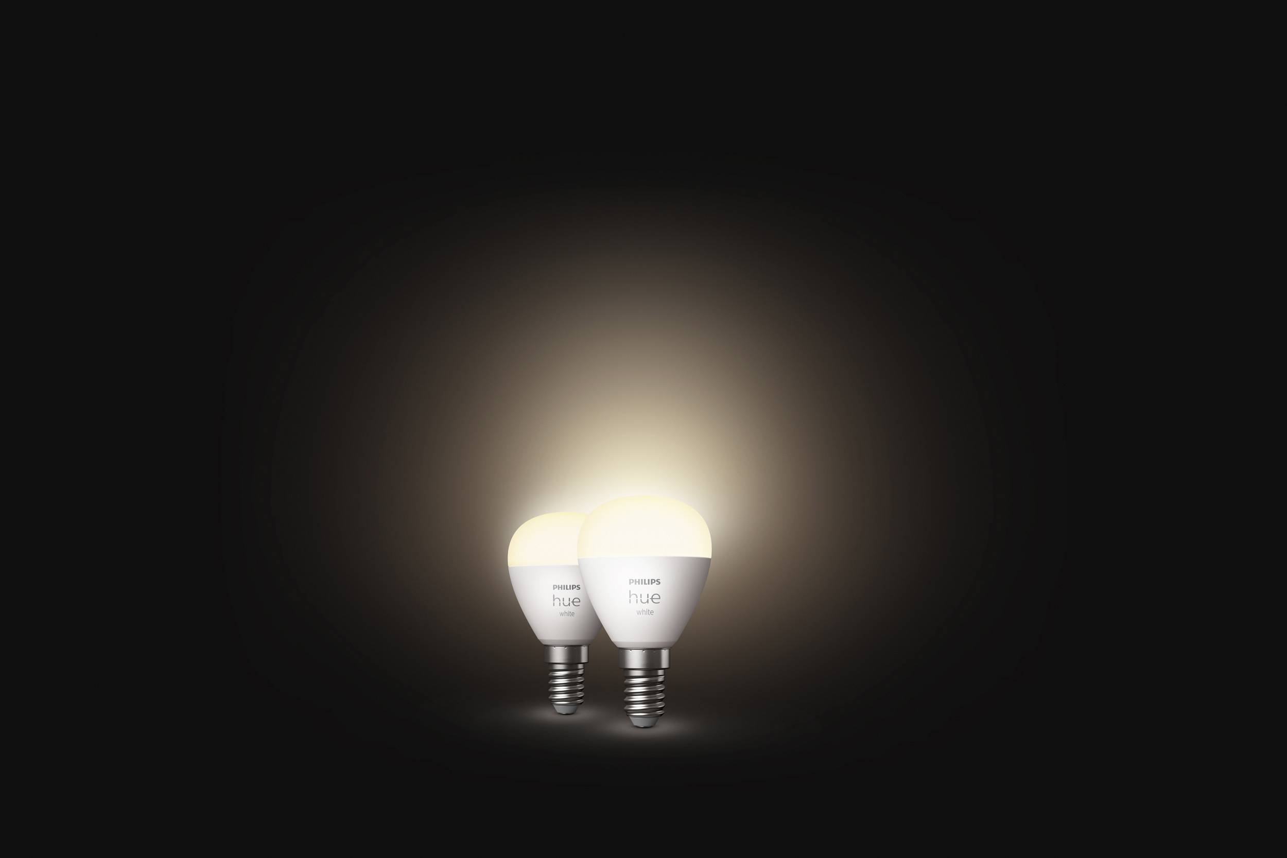 Twee stralende gloeilampen op een donkere achtergrond die warm licht uitstralen.