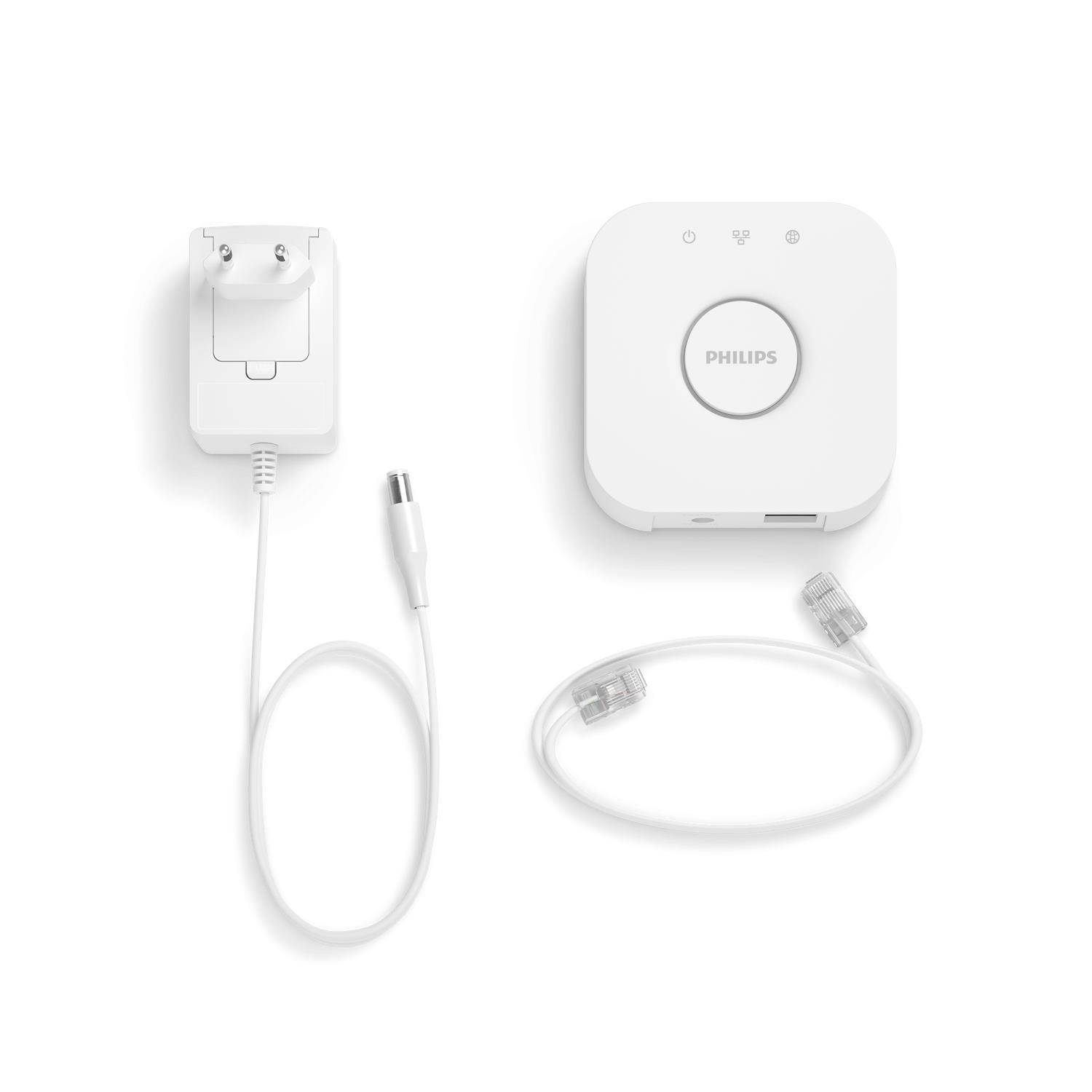 Voedingsadapter en kabel van een Philips-apparaat. Linksboven de voedingsadapter met kabel, rechts een wit dockingstation, daaronder een netwerkkabel.