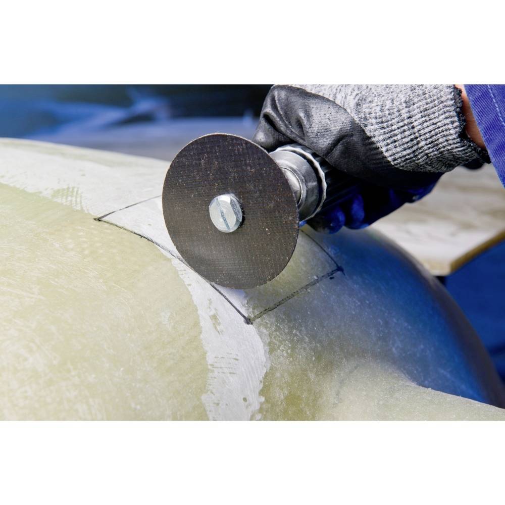 'Close-up van een vakman met handschoenen die werkt met een slijpschijf op een metalen oppervlak.'