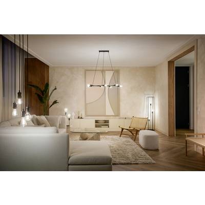 Een modern woonkamer met een beige bank, vloerkleed en een subtiel kunstwerk aan de muur. Hanglampen en planten zorgen voor een gezellige sfeer.
