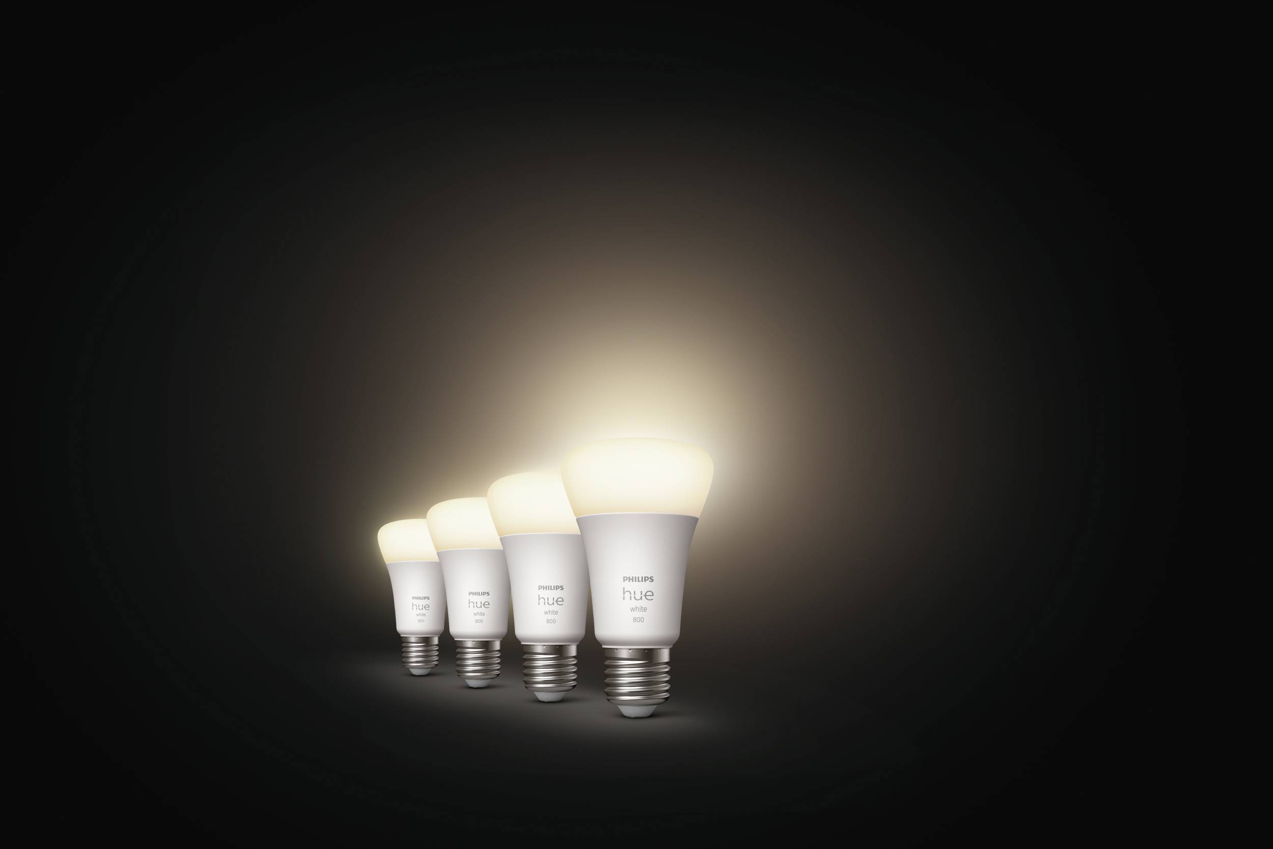 Vier lichtgevende gloeilampen op een rij tegen een zwarte achtergrond, waarbij elke lamp verder verwijderd en donkerder wordt.