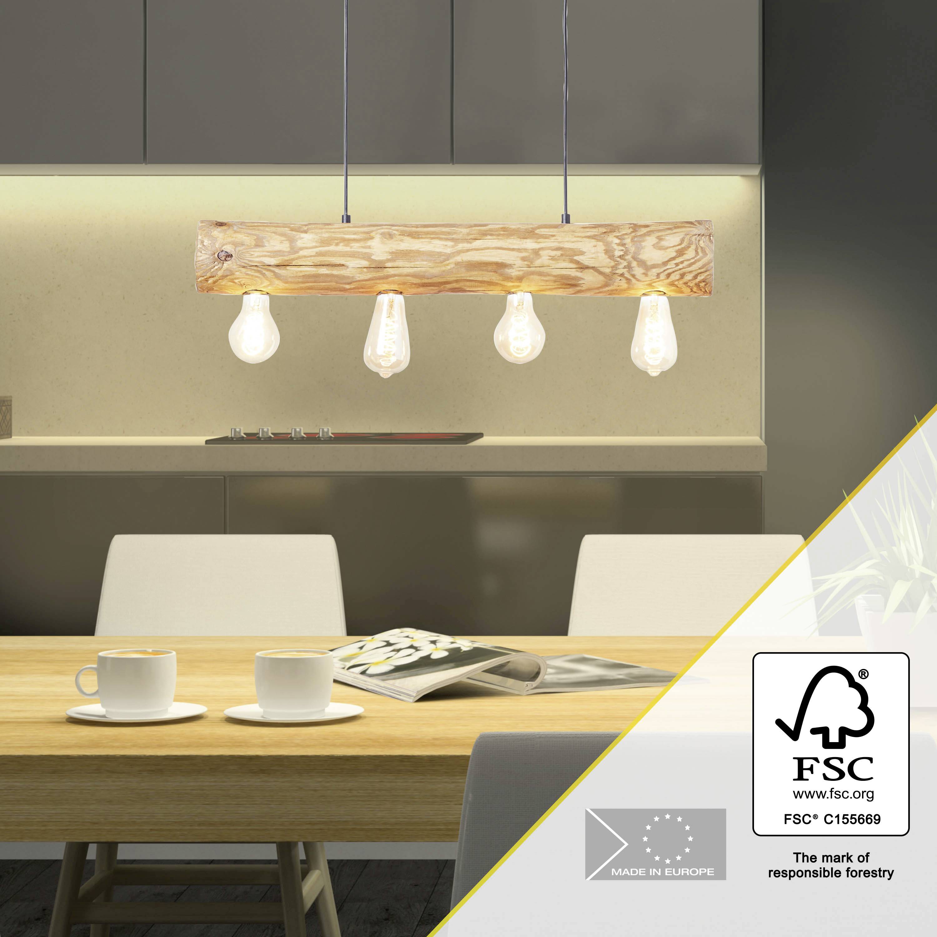Een eetkamer met een rechthoekige eettafel, waarop twee koffiekopjes en tijdschriften liggen. Boven de tafel hangt een houten lamp met zichtbare gloeilampen.