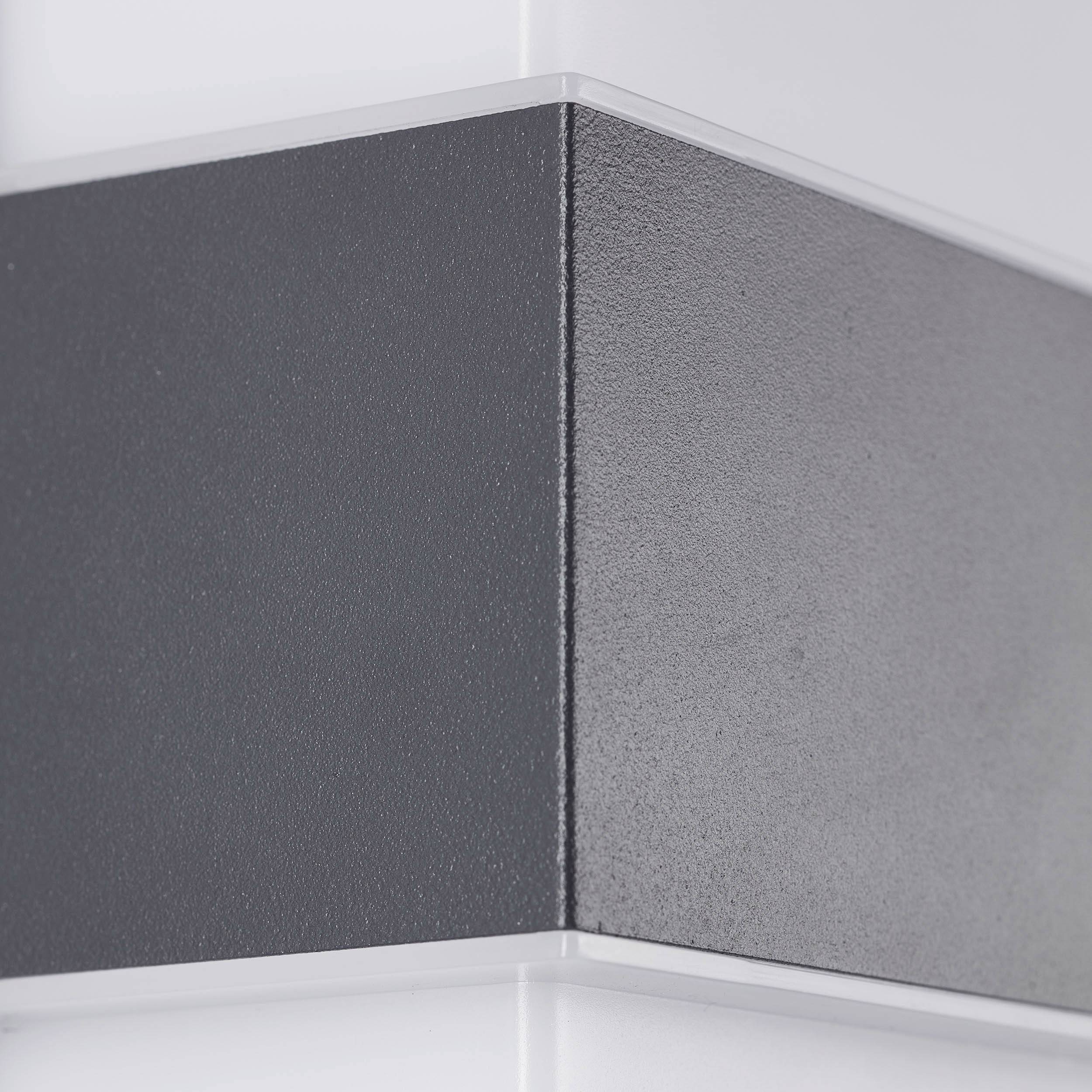 Een close-up van een wandpaneel met afwisselende zwarte en witte horizontale strepen, die een moderne esthetiek uitstralen.