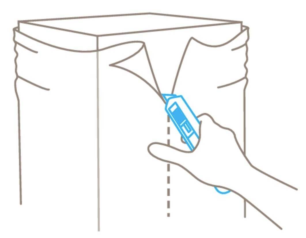 Een hand gebruikt een stanleymes om langs een kartonnen verzegellijn te snijden.