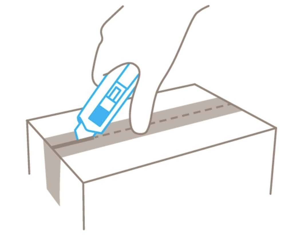 Een hand gebruikt een stanleymes om plakband op een kartonnen doos door te snijden.