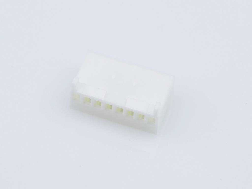 Een witte, rechthoekige kunststof stekker met meerdere contactpunten ligt op een lichte ondergrond.