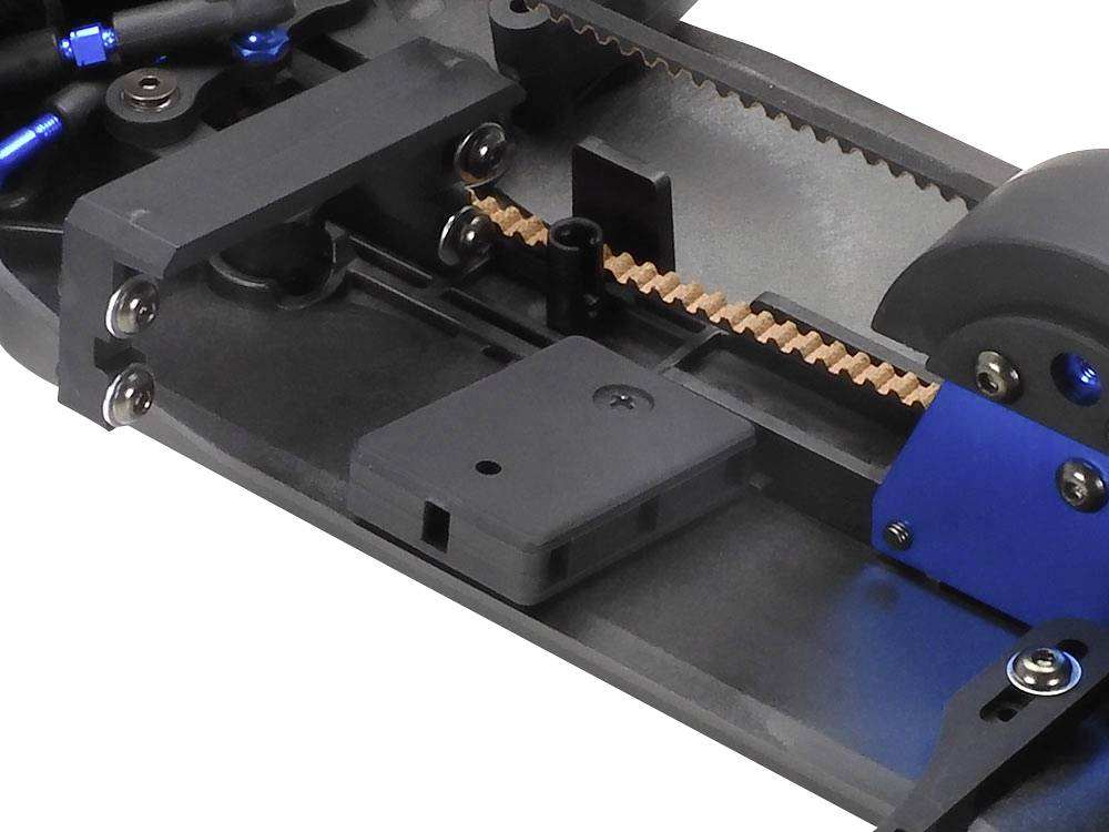 Close-up van een mechanisch onderdeel met tandriemen, blauwe en zwarte componenten. Het toont details van een technisch model.