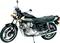 Zwarte Honda motorfiets, gezien van opzij. Chromen details en een gewatteerde zitting zijn zichtbaar. Een klassieker in de motorfietswereld.
