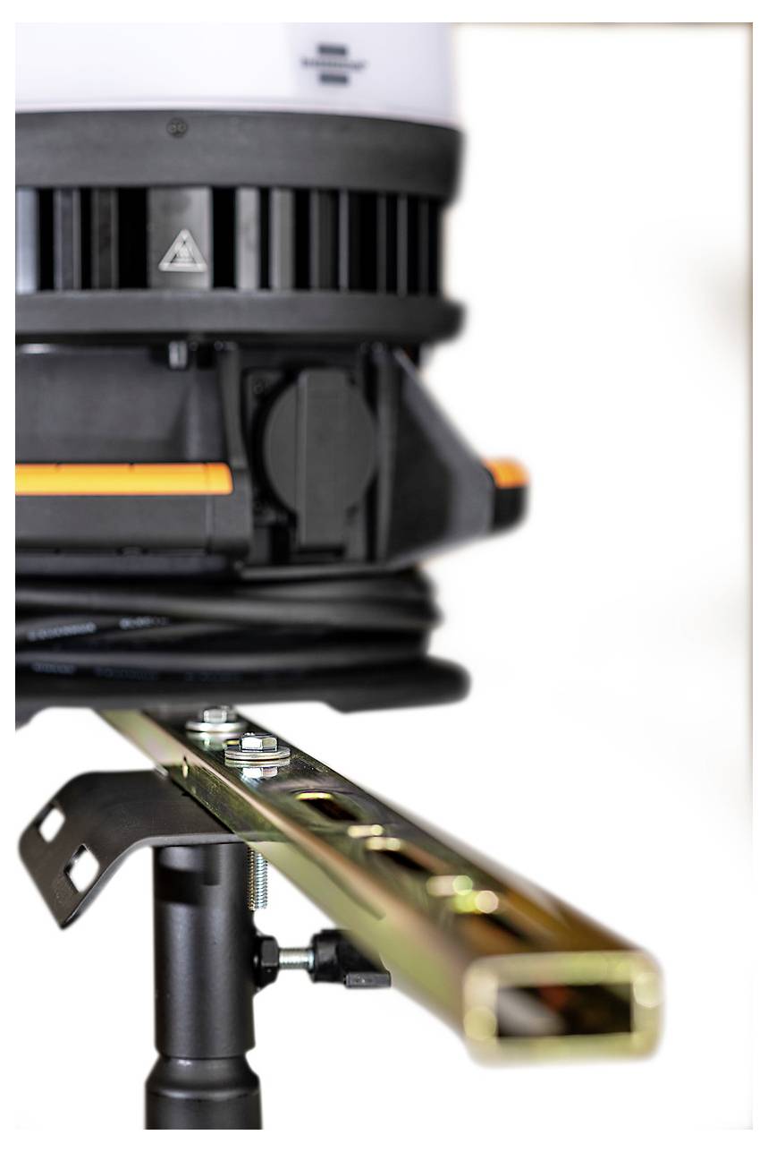 Close-up van een laserwaterpas gemonteerd op een statief, dat een horizontale oranje straal op een metalen balk of rail projecteert.