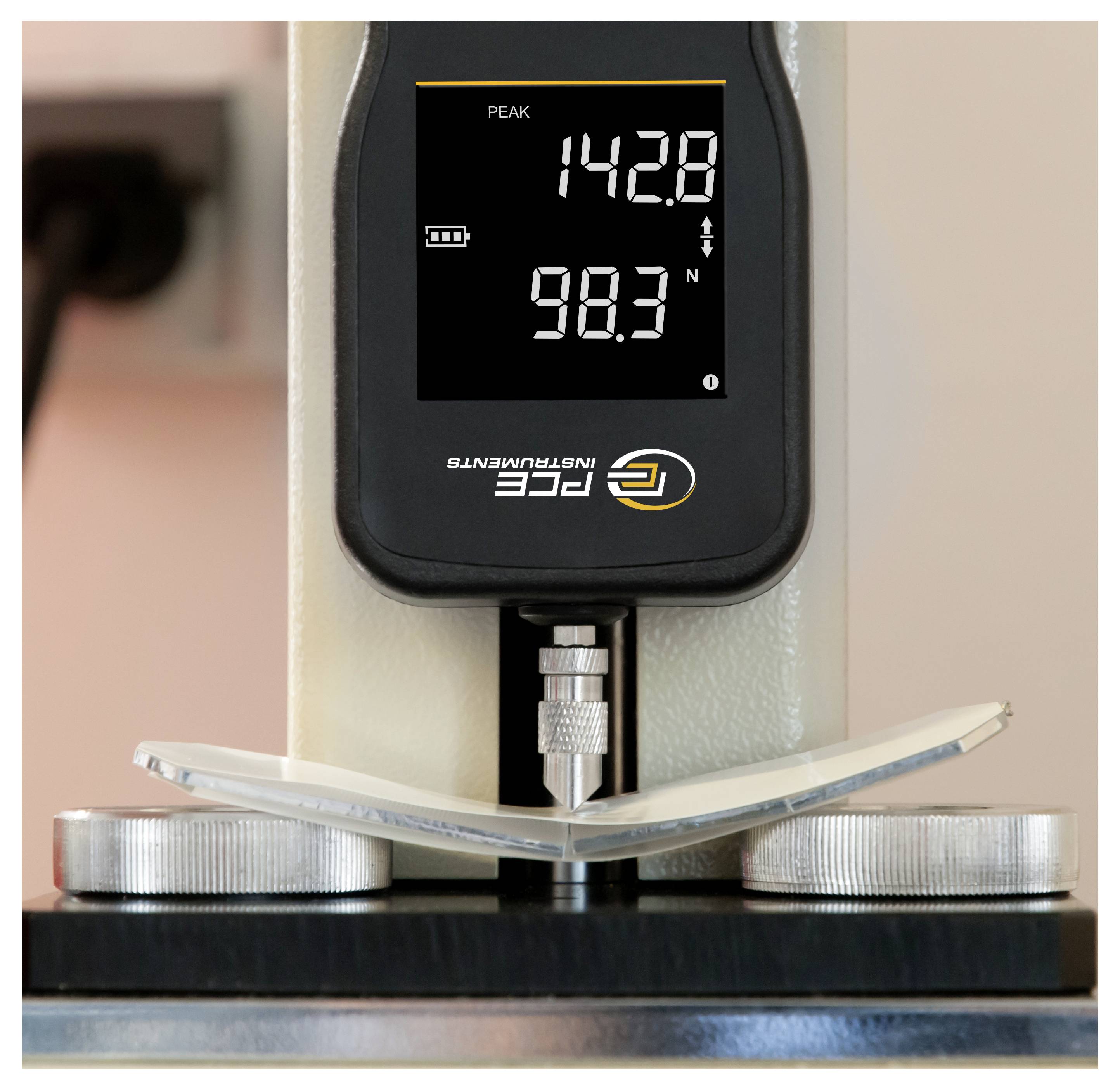 Krachtsensor test van de buiging van een dunne metaalstrip tussen twee steunpunten, waarbij de piekwaarde 142,8 en de huidige waarde 98,3 N bedraagt.