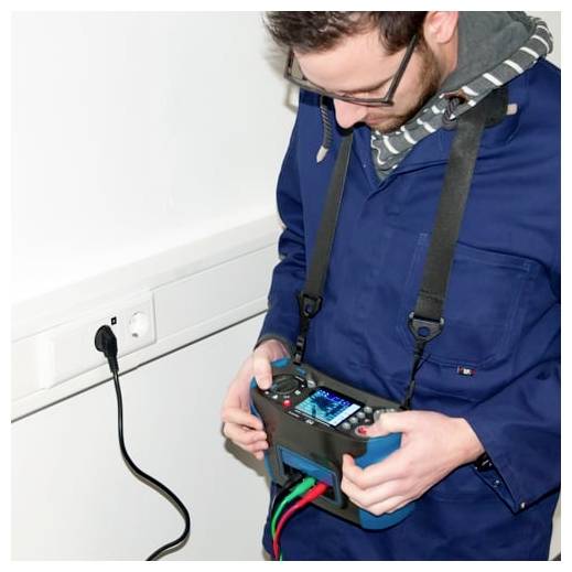 Technicus die een elektrisch apparaat inspecteert terwijl hij een kabeltesters dicht bij een wandcontact met een ingestoten snoer vasthoudt.