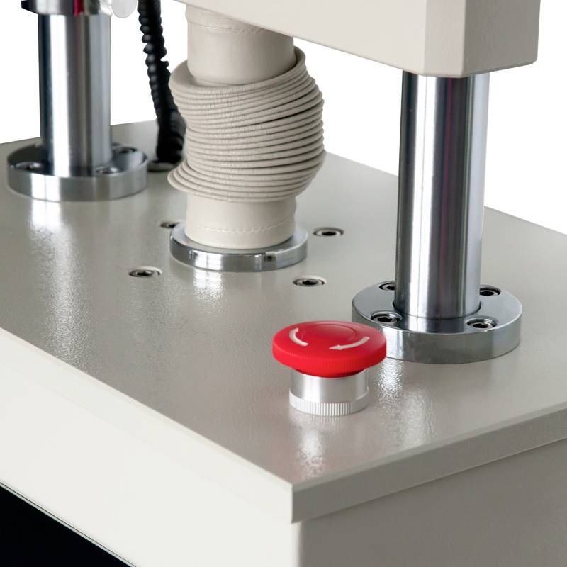 Blik op een industriële machine met zilveren metalen onderdelen en een rode knop. Deze elementen maken deel uit van een groter apparaat.