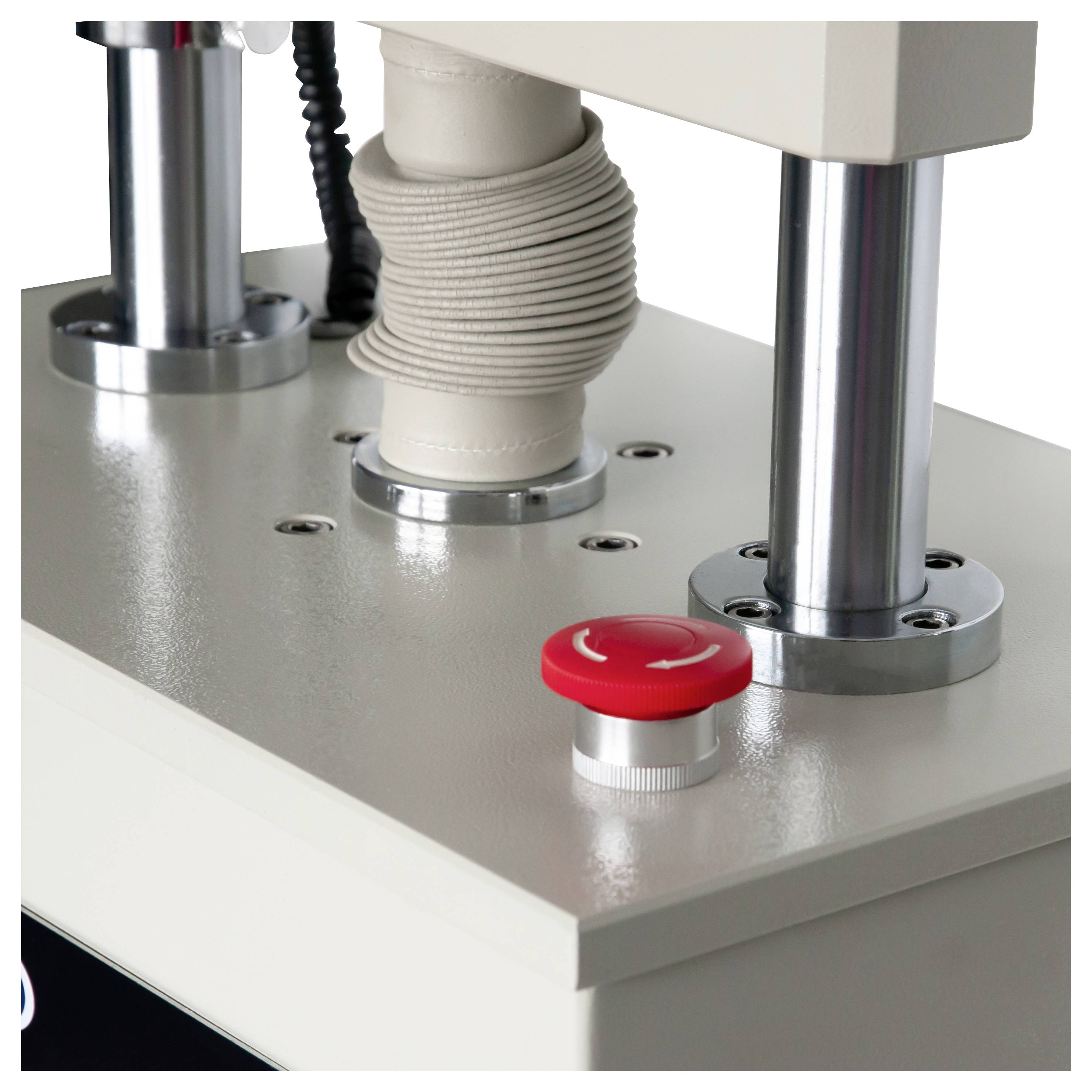 Close-up van een testmachine met een rode noodstopknop en een vastgeklemde centrale component op een metalen basis.