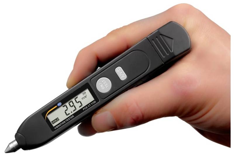 Hand die een digitale pen-stijl trillingmeter vasthoudt die een aflezen van 29,5 op het scherm weergeeft.