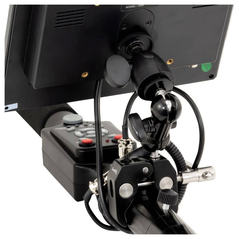Close-up van een gemonteerde joystick en bedieningskast bevestigd aan een monitor, met een bekabeld ondersteunend apparaat of machinebesturingsinstallatie.