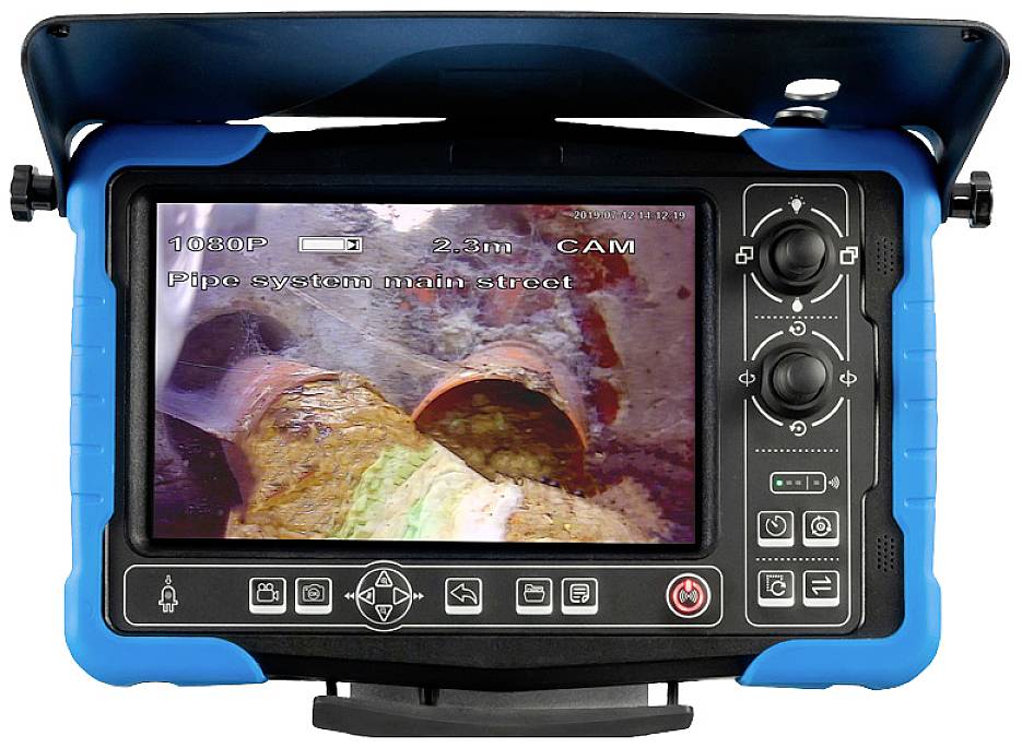 Camera-monitor toont een binnenaanzicht van een afvoerpijp met afzettingen en beschadigingen. Scherm met bedieningselementen zichtbaar.