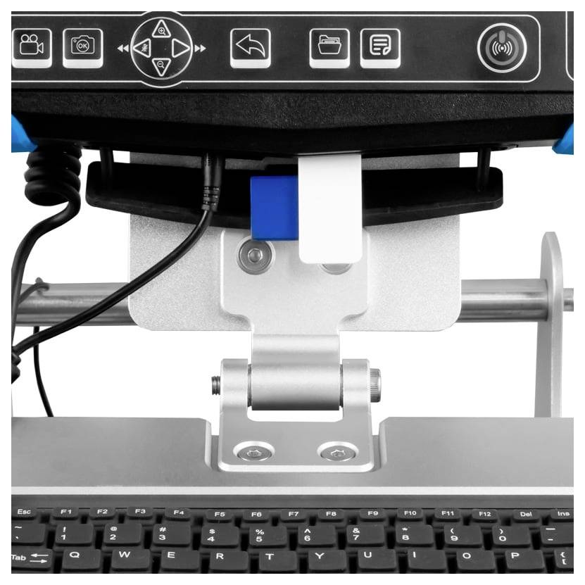 Close-up van een labelprinter met een bovenpaneel en papierinvoermechanisme boven een computerkeyboard.