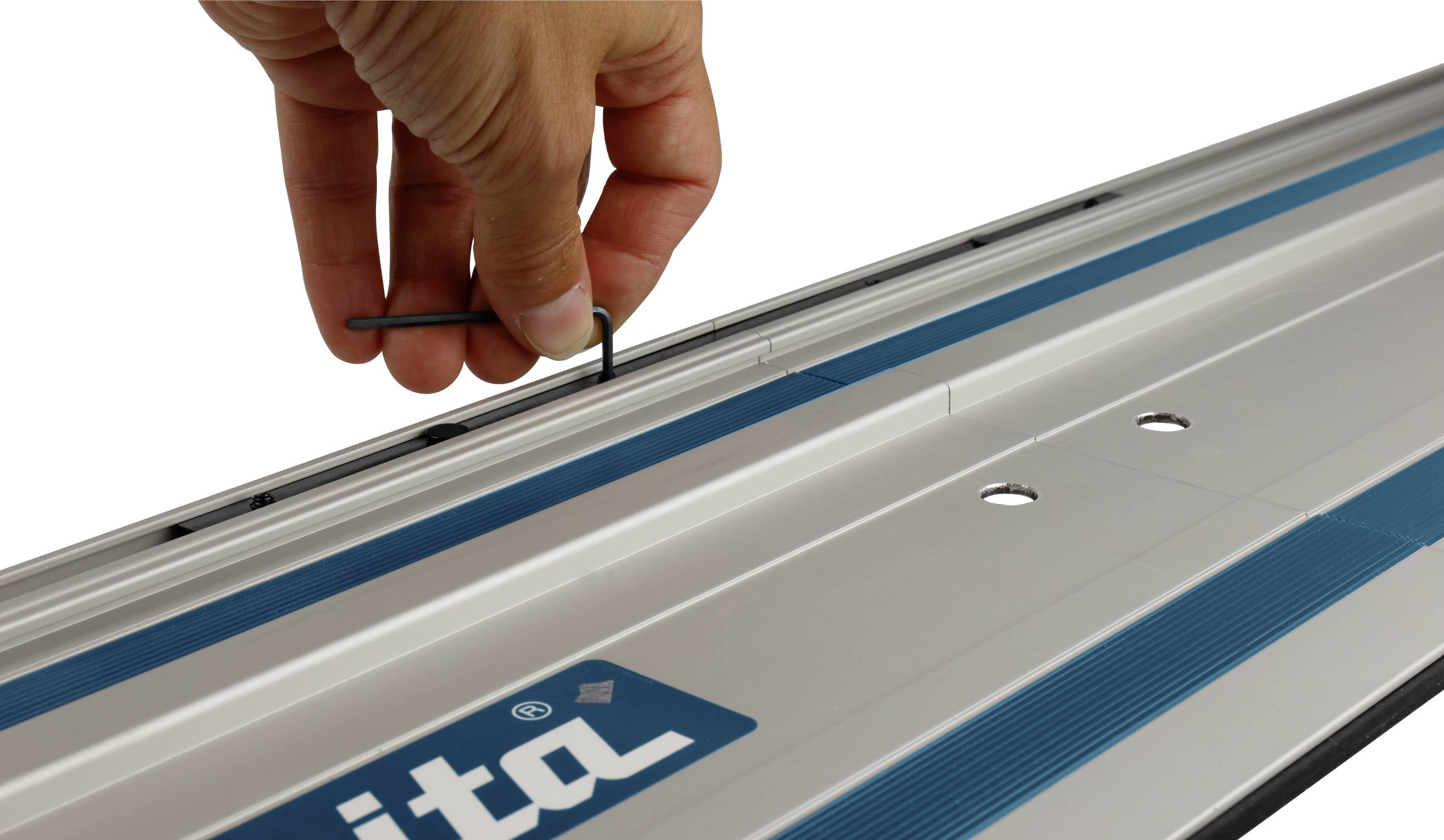 Een hand houdt een kleine moersleutel vast en past een schroef aan op een geleiderail met een blauwe streep.