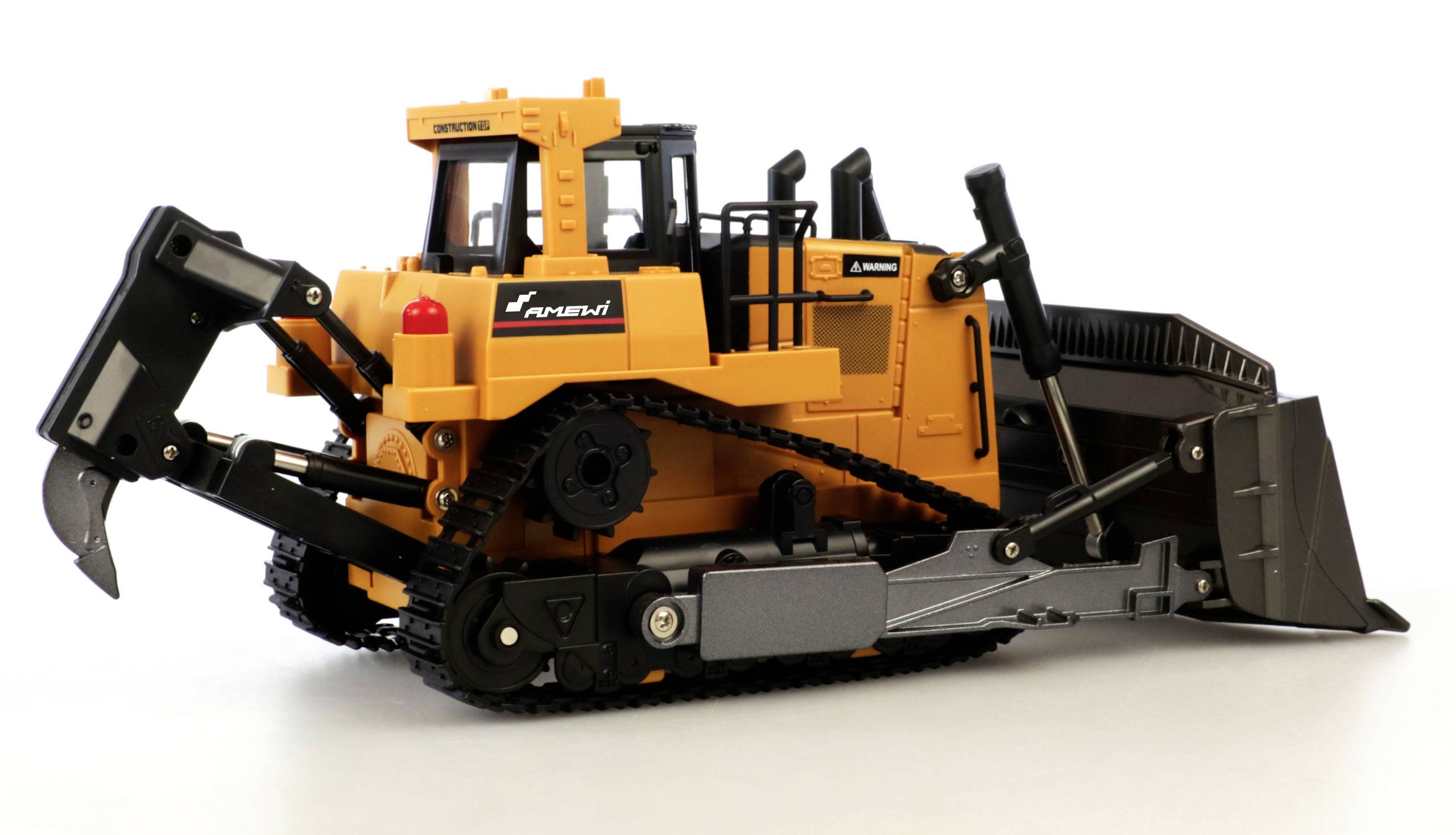 Een gele bulldozer met zwarte rupsbanden en schep staat zijdelings op een witte achtergrond. Hij heeft zichtbare hydraulische componenten.