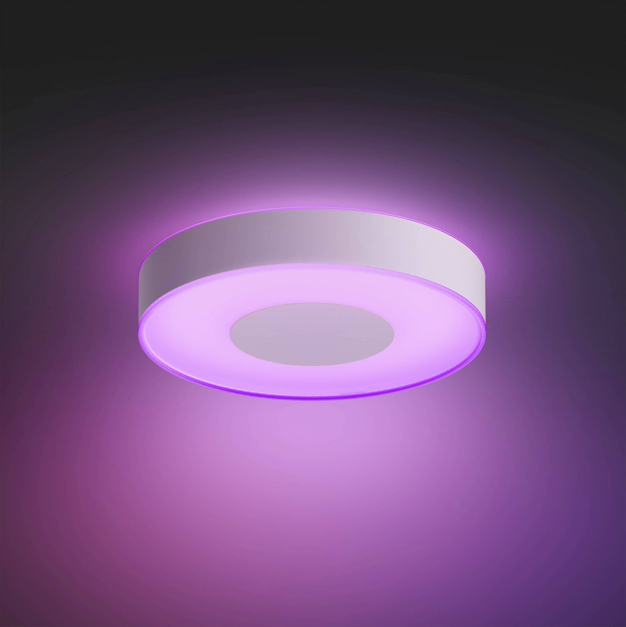 Ronde plafondlamp, straalt paars licht uit. Hangt aan een donker plafond. Modern design, warme sfeer.