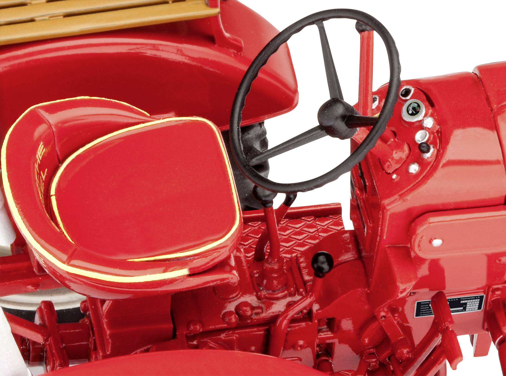 Rode oldtimer-tractor close-up, toont de bestuurdersstoel, het stuur en instrumentenpaneel, in klassiek design.