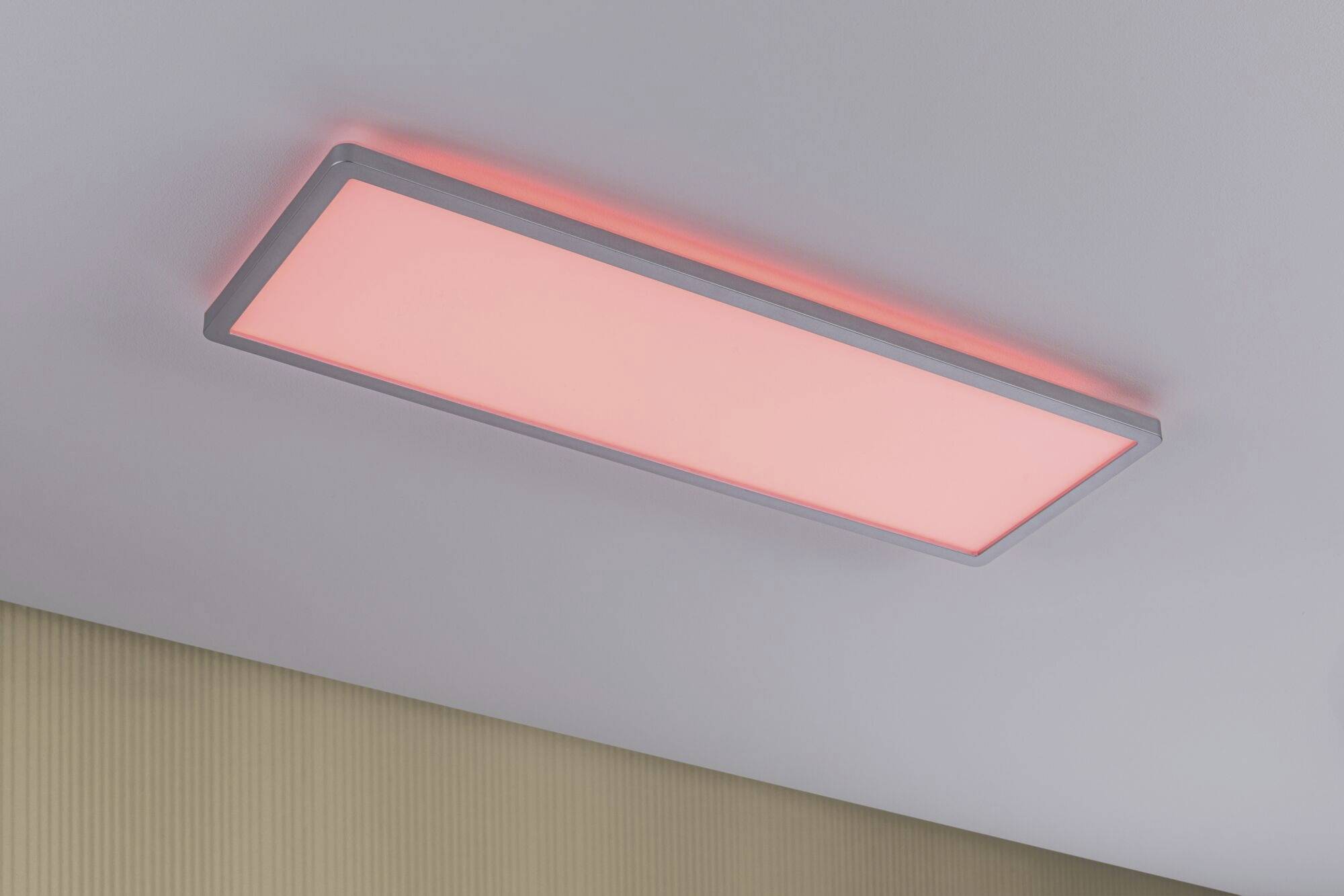 Een rechthoekige plafondlamp straalt een zacht rood licht uit.