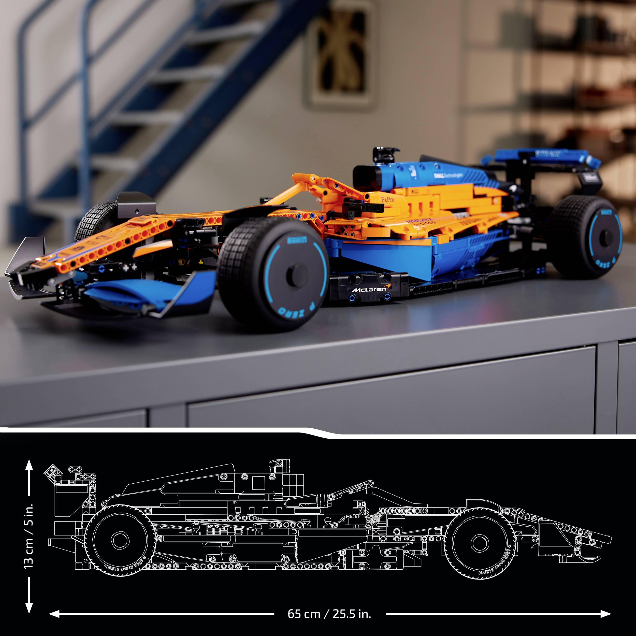 Een gedetailleerd model van een racewagen gemaakt van bouwstenen op een tafel. Ernaast een schets met de afmetingen: 13 cm hoog, 65 cm lang.