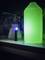 Zaklamp verlicht groene vloeistof in een fles, scheikundige laboratoriumuitrusting op de achtergrond, donkere omgeving.