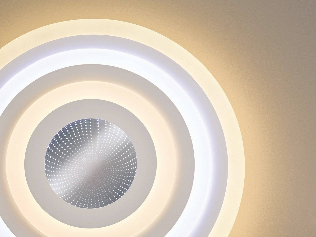 Cirkelvormig kunstwerk met een centraal punt en lichtgevende, concentrische cirkels die van binnen naar buiten steeds bleker worden.