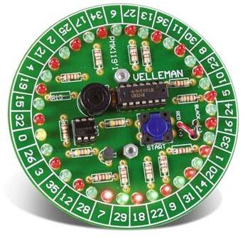 Ronde groene printplaat met elektronische componenten en led's. Opschrift 'VELLEMAN'. Getallen 1-36 aan de rand. Een knop met 'START'.