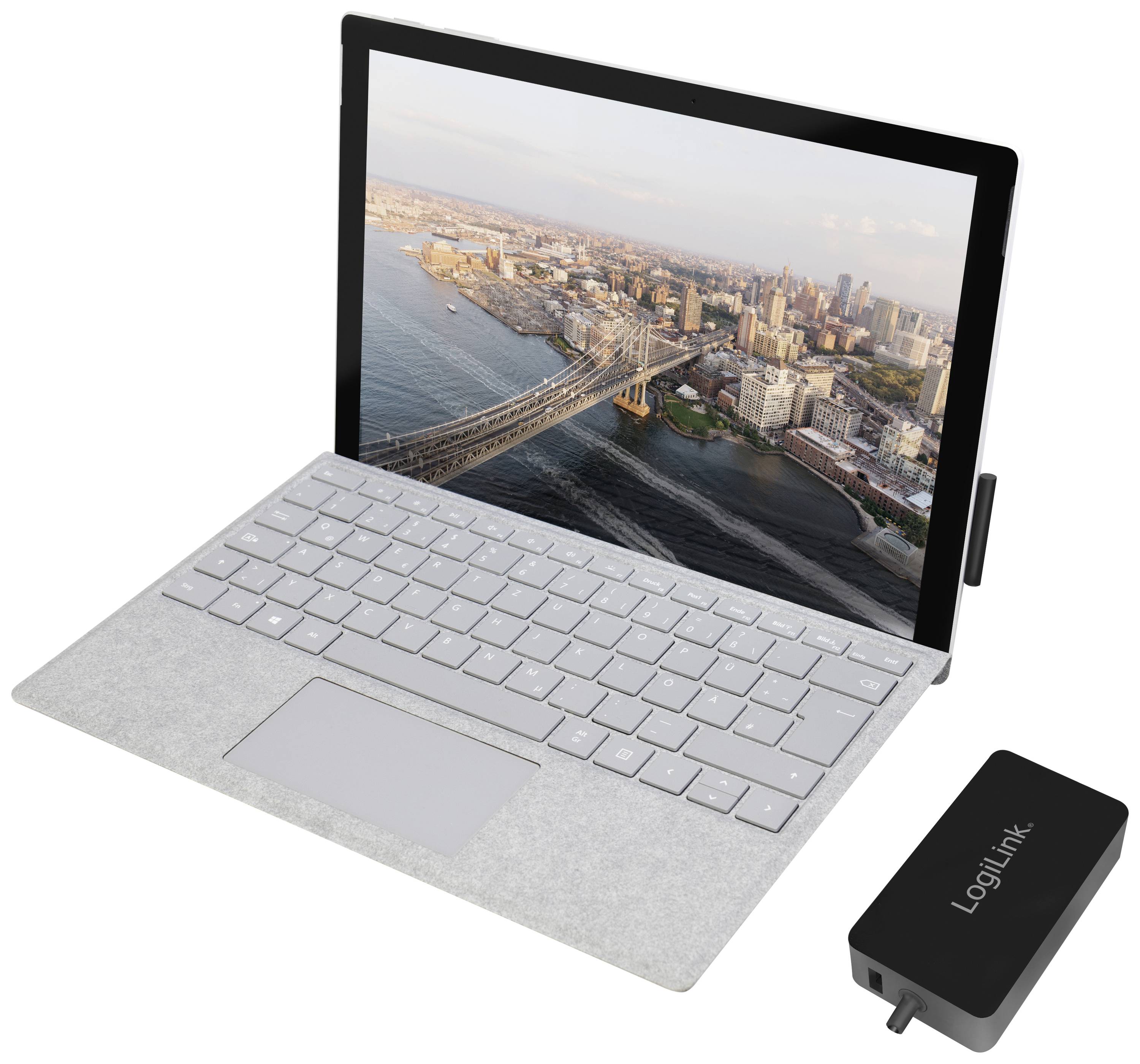 Een laptop met een afbeelding van New York op het scherm en een LogiLink-oplader ernaast.