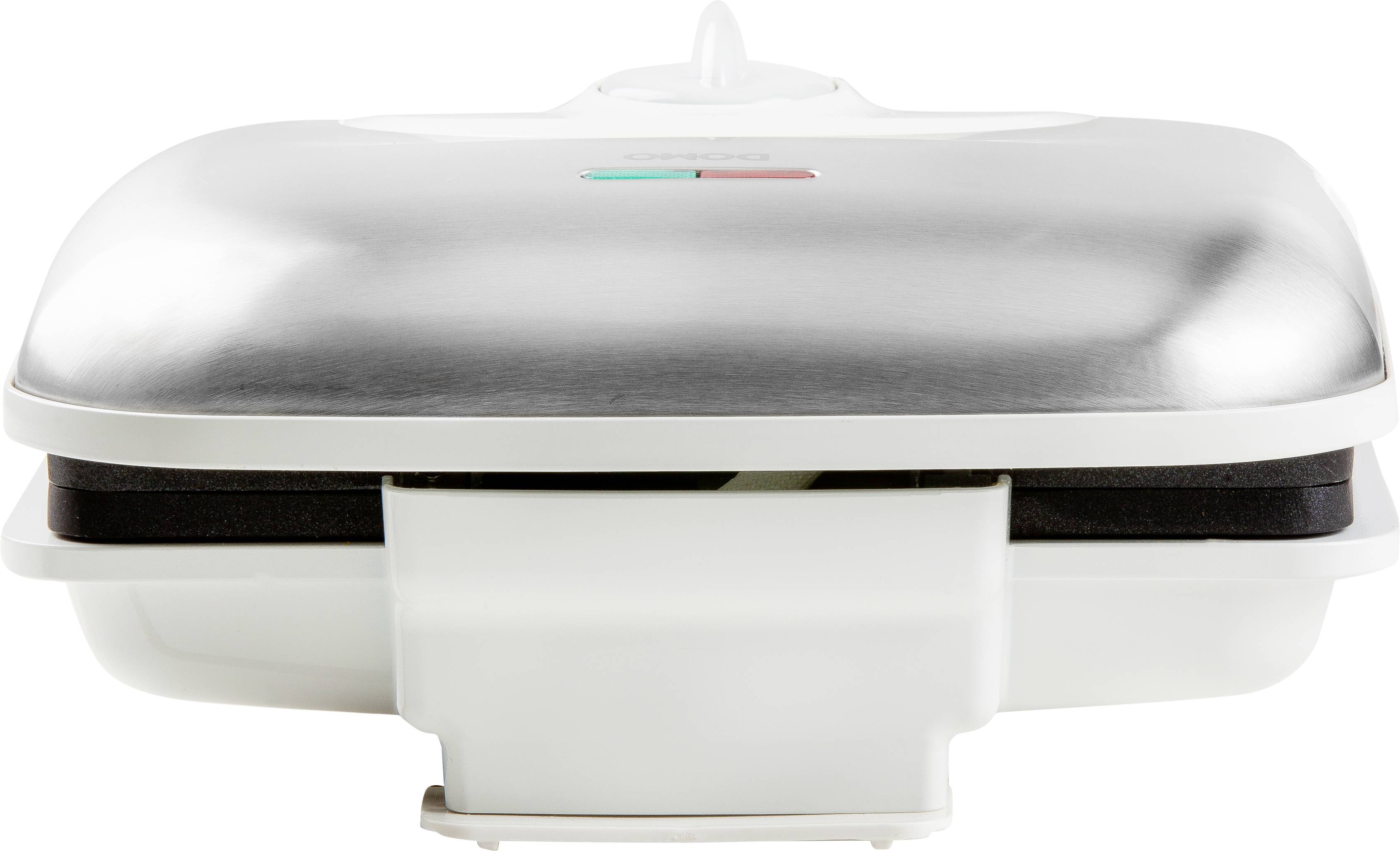 Een zilveren wafelijzer met gesloten deksel, op een witte ondergrond, toont een controlelampje bovenaan.