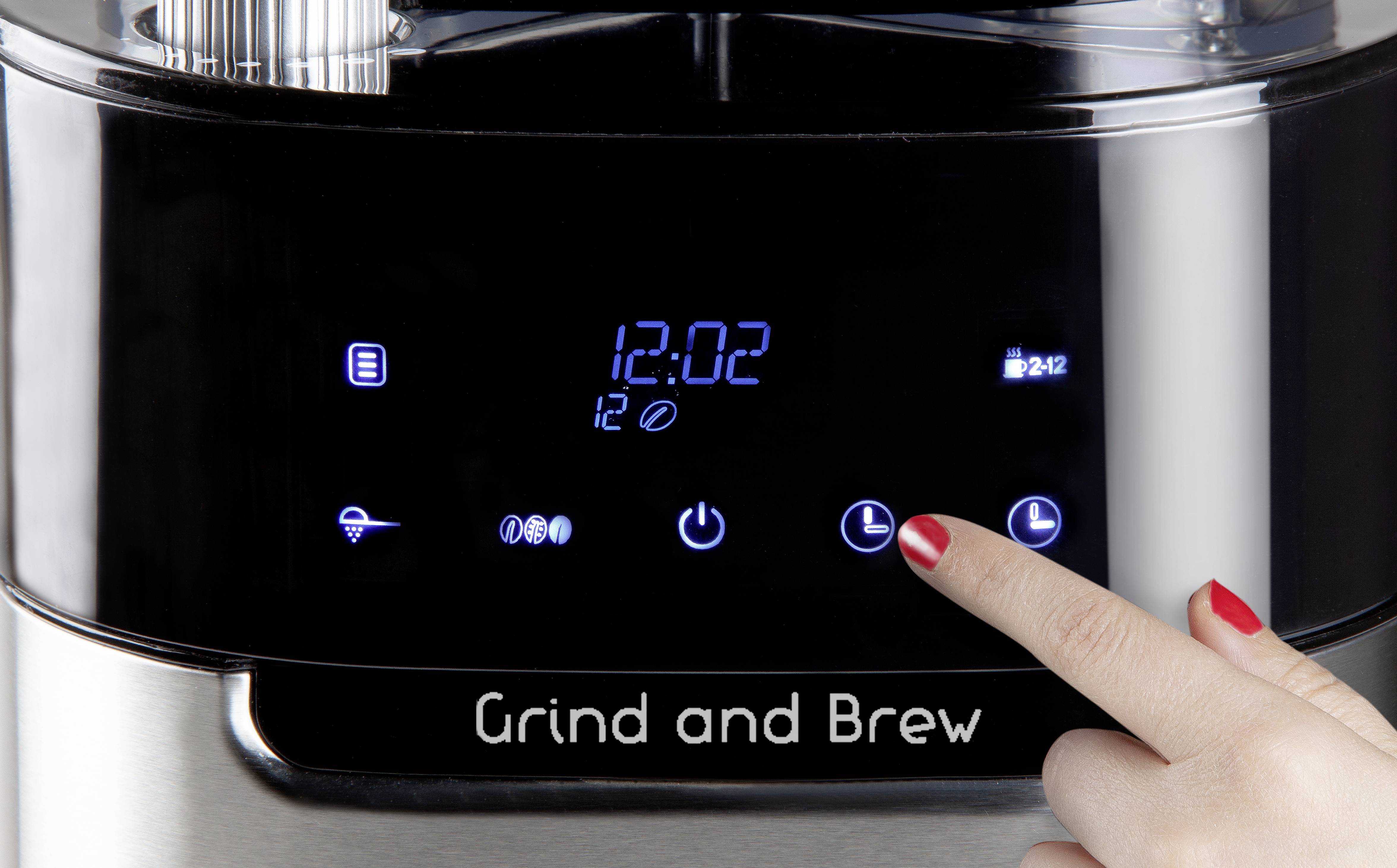 Een persoon tikt op het touchscreen van een koffiemachine met een tijdsweergave van '12:02'. Knoppen voor functies en timer zijn zichtbaar.