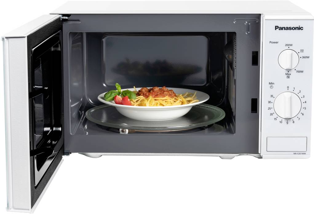 Een open magnetron toont een bord met pasta en tomatensaus van binnen, klaar om opgewarmd te worden.