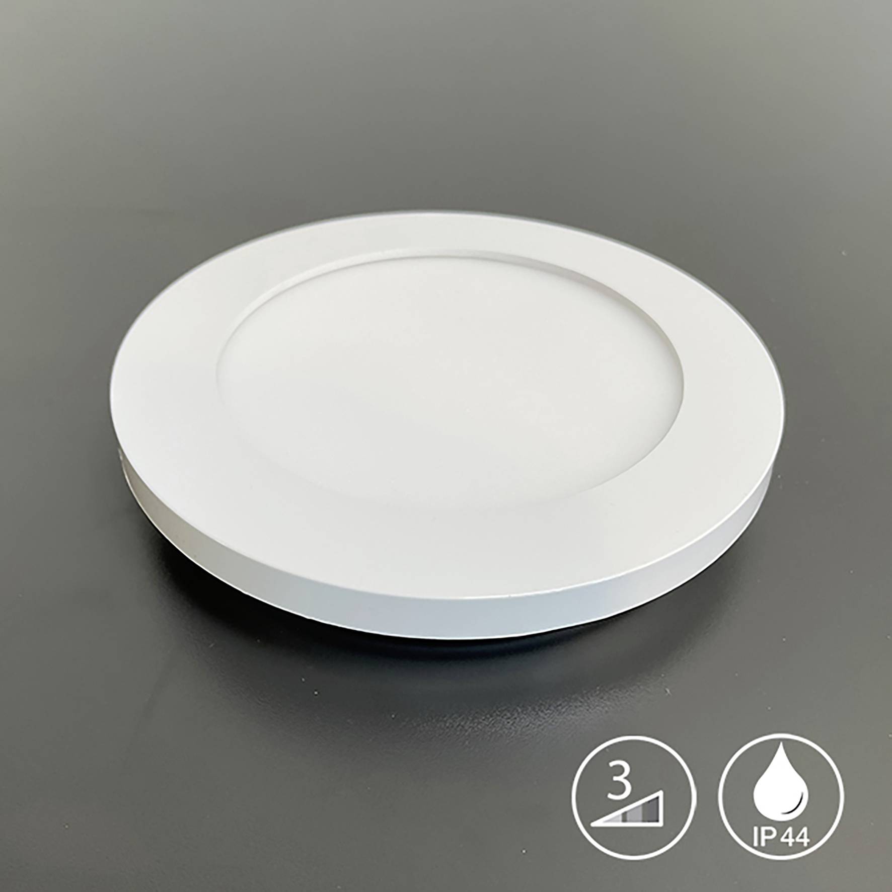 Een ronde, witte led-plafondlamp op een zwarte achtergrond met symbolen voor helderheidsinstelling en beschermingsgraad IP44.