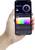 Een hand houdt een smartphone vast met een app die de kleurregeling van een lamp laat zien. Een spectrum aan kleuren en een helderheidsschuifregelaar zijn zichtbaar.