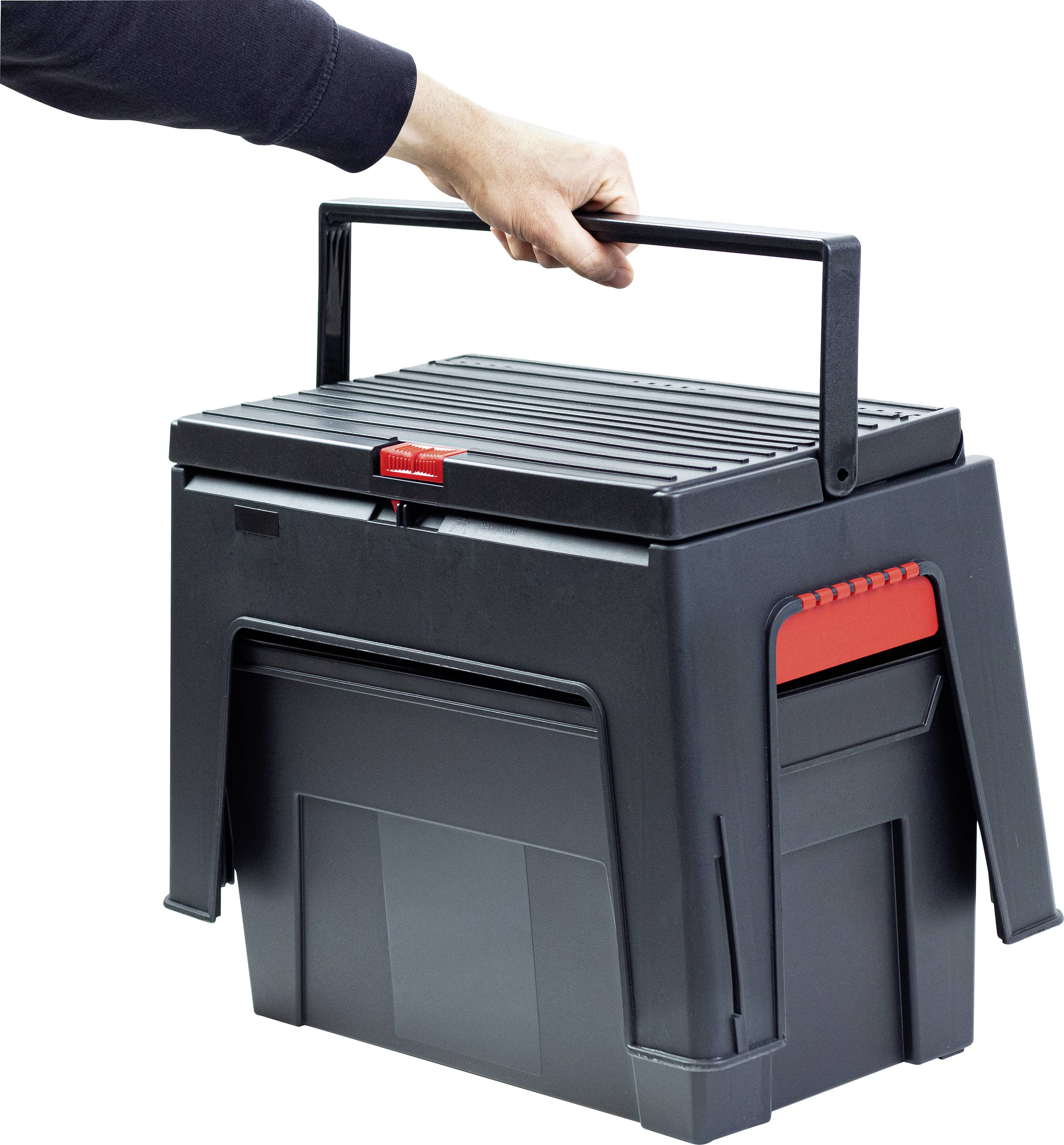 Een hand houdt een draagbare, zwarte gereedschapskist met een rode sluiting vast. De kist heeft een opklapbare handgreep en ribpatroon bovenop.