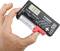 Een hand houdt een batterij-tester vast met een AA-batterij erin. Het display toont '1.37V'.
