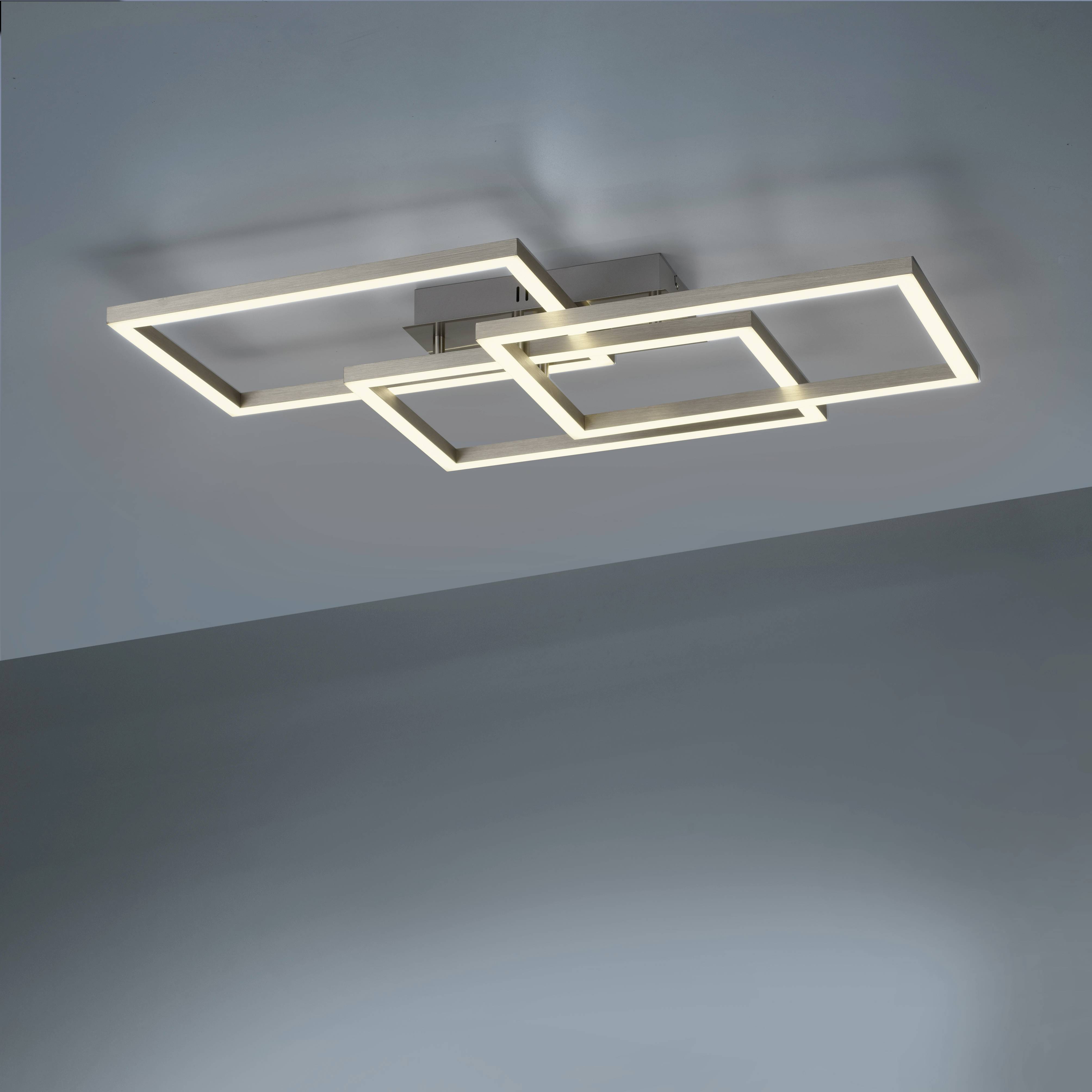 Moderne, geometrische plafondlamp met vierkante, overlappende metalen frames en LED-verlichting in een strakke ruimte.