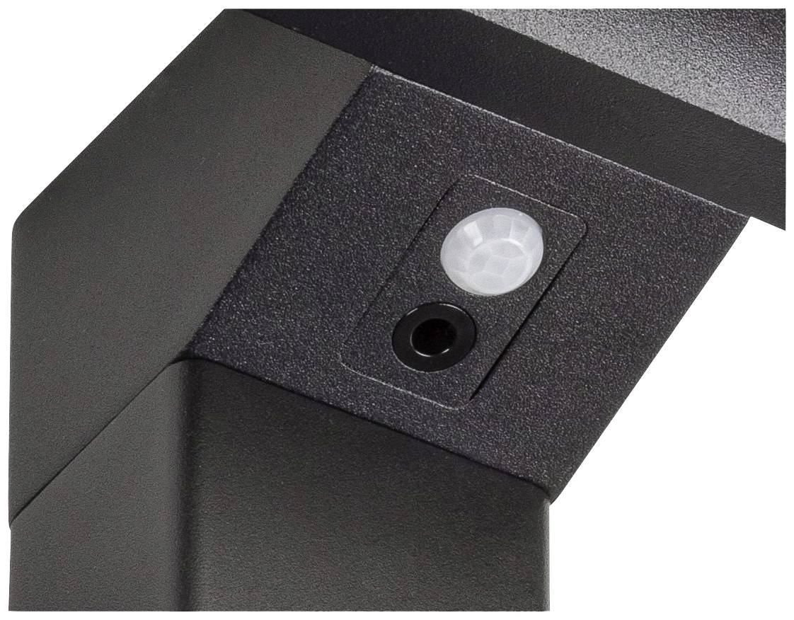 Een zwarte bewegingssensor met een herkenbare ronde detector, gemonteerd op een metalen hoek.