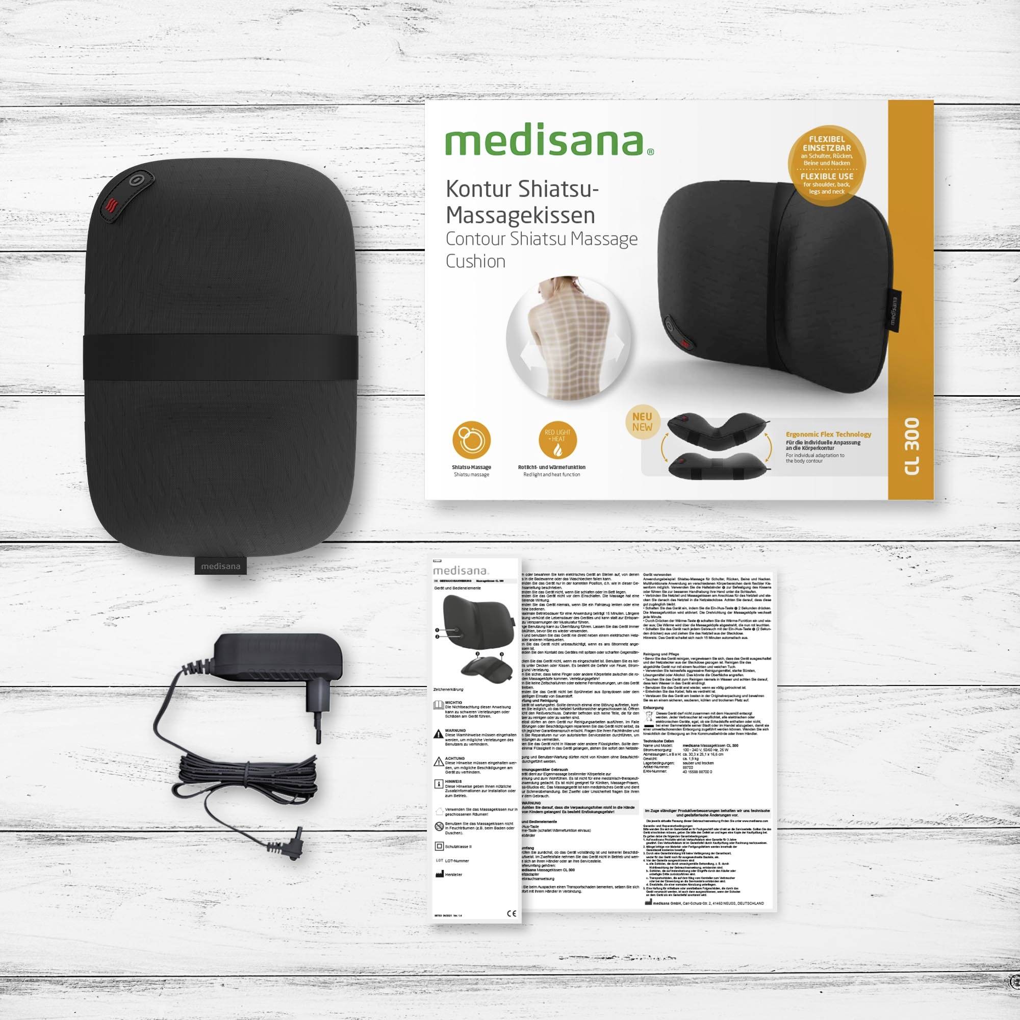 'Medisana Kontur Shiatsu-massagekussen' verpakking met afbeelding van het kussen, gebruiksaanwijzing en voedingsadapter op witte houten ondergrond.