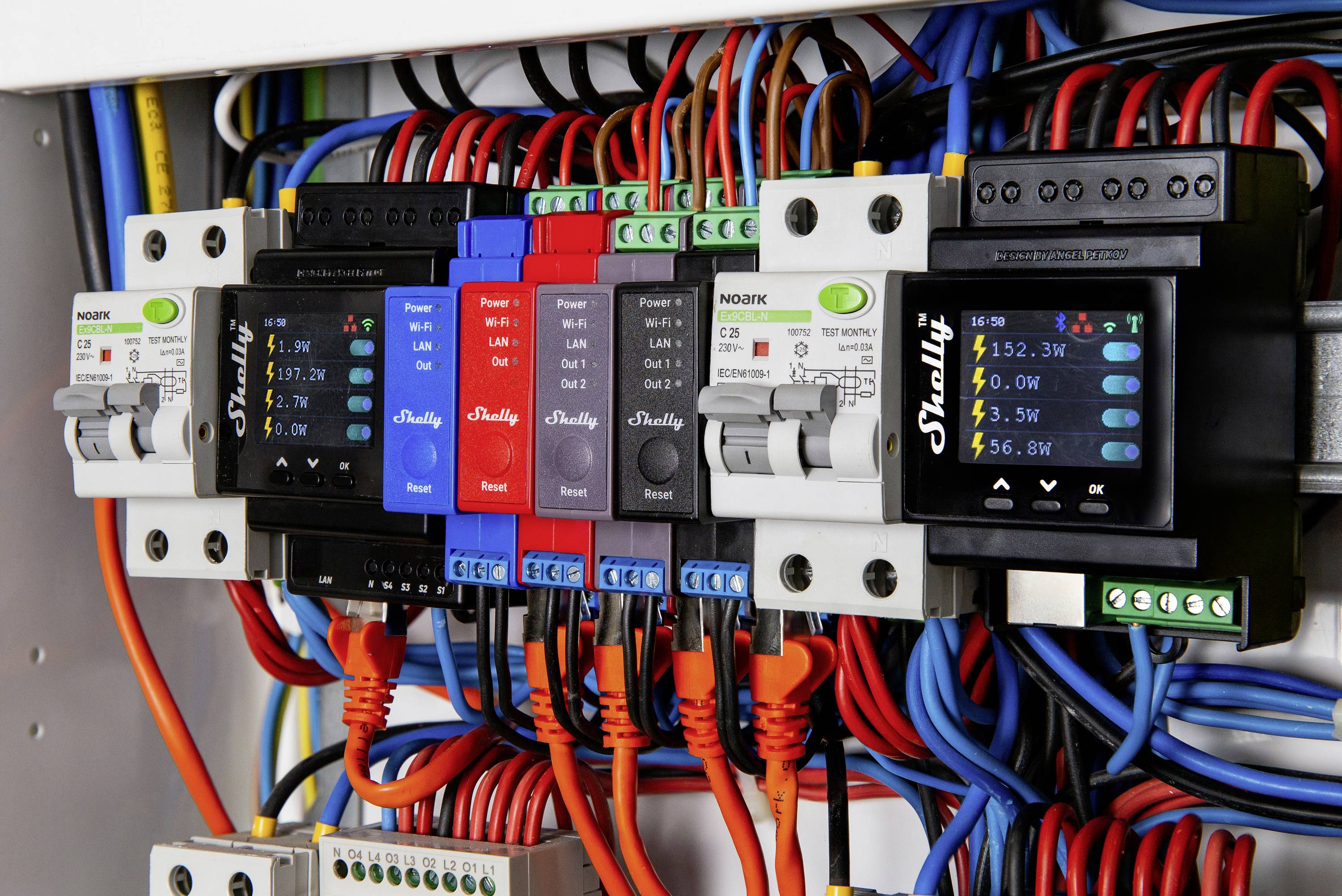 Meerdere digitale energiemeters met gekleurde kabels tonen verschillende vermogenswaarden tussen 5,97 kW en 5,66 kW.