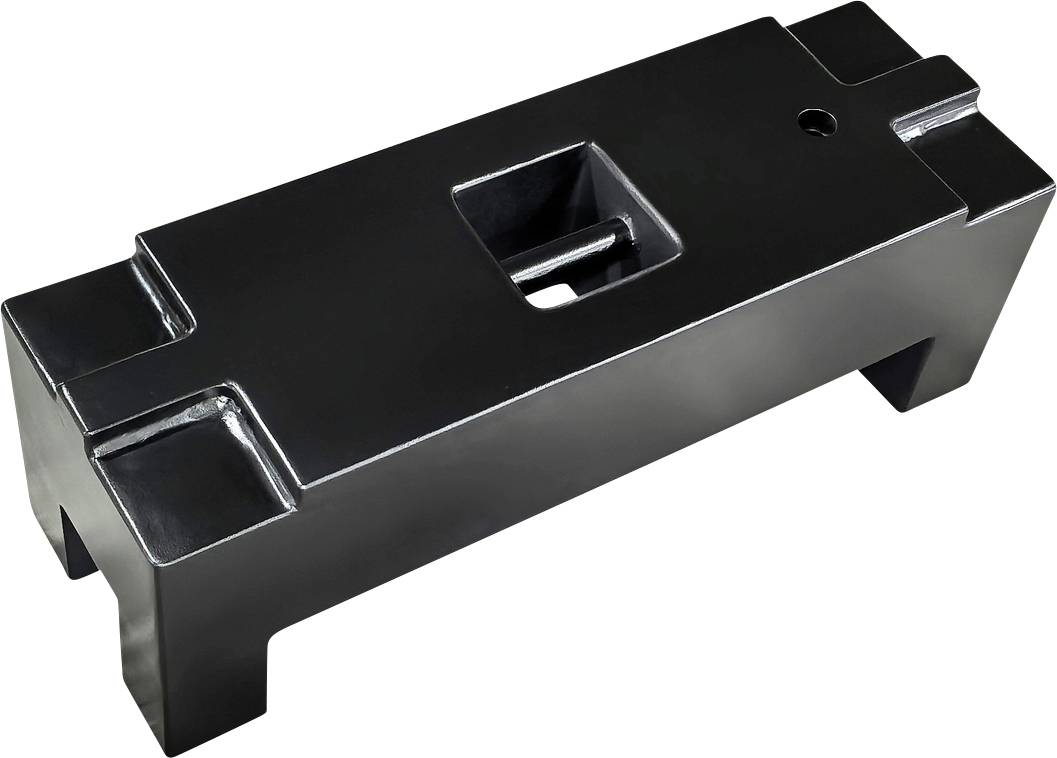 Een rechthoekige, zwarte metalen blok met een centraal rechthoekig gat en vier korte steunpoten in elke hoek.