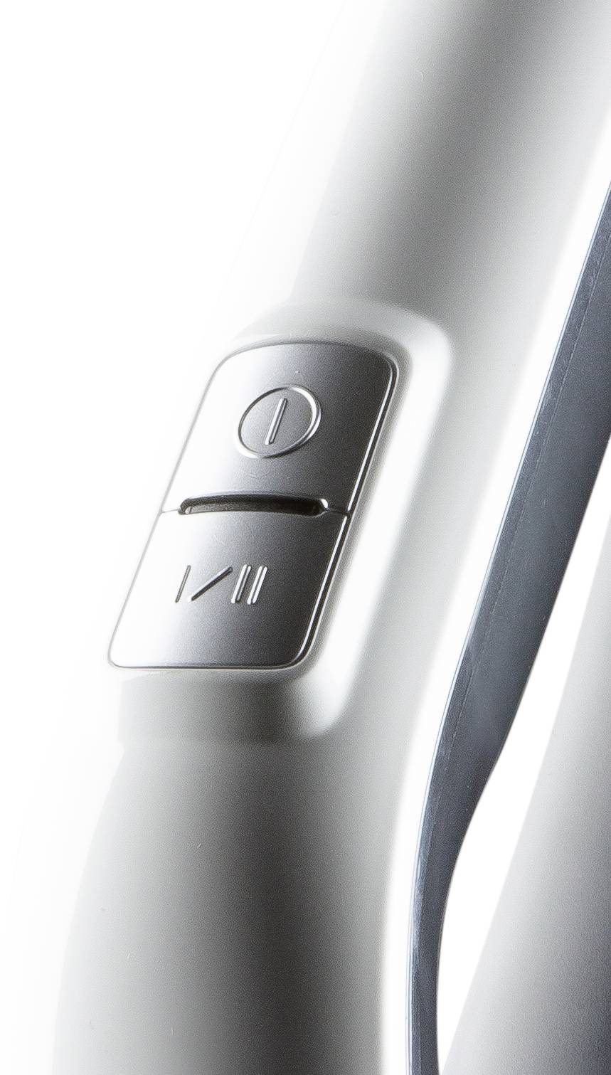 Zilveren knop met aan/uit-symbool op een witte achtergrond, waarschijnlijk deel van een elektronisch apparaat.