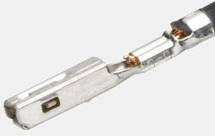 Close-up van een metalen pin die deel lijkt uit te maken van een elektrische connector. De pin heeft koperen contactpunten.